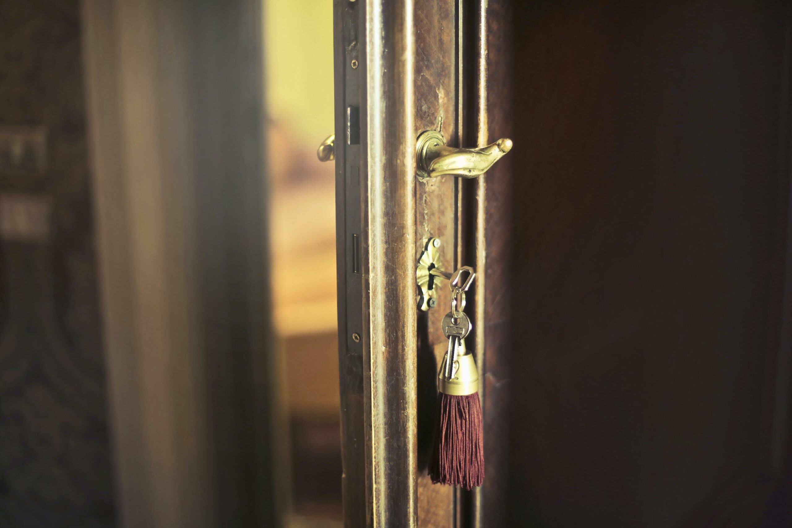 Close-up of a vintage door with an antique key and tassel, highlighting a rustic design.